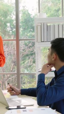 İş adamları ofisteki proje planlama kurulunda çalışıyor ve proje gelişimini analiz etmek için iş arkadaşlarıyla sohbet ediyorlar. Düzenli olması için cam duvara yapıştırılmış yapışkan notlar kullanıyorlar. .