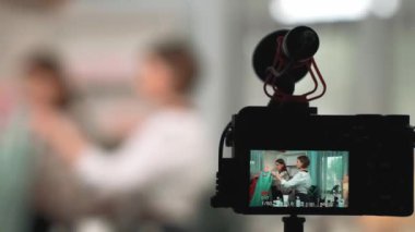 Arka görünüm, kamera ekranının arkasında iki kadın nüfuzlu görüntüleyicinin video görüntülerini, video görüntülerini, kıyafetleri, sosyal medyayı ya da blogu görüntülemesini gizler. Canlı yayın için stüdyo ışıklandırmalı kızlar canlı yayın pazarlama kayıt oturumu