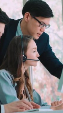 Ofiste çalışan kulaklık takan işadamları uzak müşteri ya da meslektaşlarını desteklemek için çalışıyorlar. Arama merkezi, tele pazarlama, müşteri destek acentesi telefon görüşmesinde hizmet sunar.