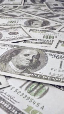 Ofis masasında 100 dolarlık kağıt para yığını. Maliye ve para ödemesi kavramı.