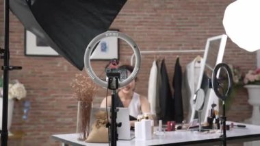 Kadın nüfuzlu kişi sosyal medya ya da blog için canlı yayın yapan video klip eleştirmeni derisini çekiyor. Canlı kozmetik stüdyosu ışıklandırması olan mutlu genç bir kız pazarlama için internet üzerinden yayın yapıyor..