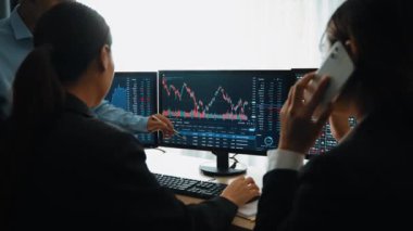 Hisse senedi borsası pazarlamasını analiz eden yavaş çekim şirketindeki yatırımcılar, kayıp için mum bar fiyatını analiz eden monitörlere bakıyor ve kazanç ve kâr elde ediyor. Filizlenen