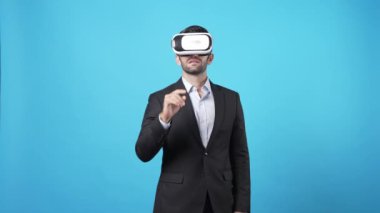 Yetenekli proje yöneticisi VR gözlük takıp online toplantıya katılırken pazarlama fikrini konuşuyor ve paylaşıyor. Zeki iş adamı mavi arka planda mali raporu birbirine bağlıyor. Aygıt.