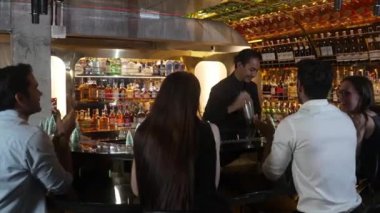 Gülümseyen Asyalı barmen, VIP konuğuyla konuşurken süslü Noel ağacı tezgahında karışık kokteyl hazırlıyor. Bar lüks 'te gece hayatı sunan özel bir içecek. Vinosity.