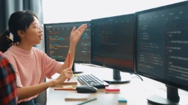 Yavaş çekim arkası yazılım geliştirici mühendisi bilgisayar programlama için birlikte çalışarak hata ayıklama kodunu çözüyor, ofiste monitörde karmaşık algoritmaları çözüyor. Filizlenen
