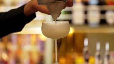 Yakın plan el barmeni votka, hindistan cevizi pürüzsüz köpüklü kokteyl kullanarak lüks tezgah hazırlıyor ve ön taraftaki barda misafir için özel bir şeyler hazırlıyor. Gece hayatını canlandıran özel bir sergi. Vinosity.