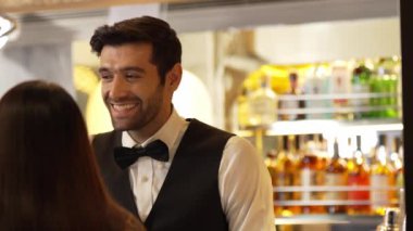 Yakışıklı, güler yüzlü bir barmen arkadaş, VIP müşterilerine içki listesi öneriyor. İçki tezgahı lüks, profesyonel barmen kostümü içinde harika bir ilk izlenim bırakıyor. Vinosity.