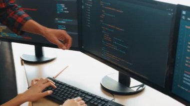 Yavaş çekimde geri uç veya yazılım geliştirici yöneticisi ekibini monitörde hata ayıklama ve karmaşık kod algoritmalarını çözmede yeni uygulama programı geliştirmede denetliyor. Filizlenen