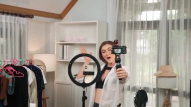 Kadın nüfuzlu kişi video görüntülerini canlı yayınlıyor. Kıyafetler sosyal medyada ya da blogda yer alıyor. Stüdyo ışıklandırmalı mutlu genç kız çevrimiçi pazarlama oturumu yayını için..