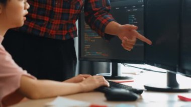 Yavaş çekimde geri uç veya yazılım geliştirici yöneticisi ekibini monitörde hata ayıklama ve karmaşık kod algoritmalarını çözmede yeni uygulama programı geliştirmede denetliyor. Filizlenen