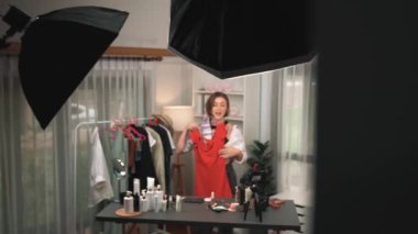 Kadın nüfuzlu kişi video görüntülerini canlı yayınlıyor. Kıyafetler sosyal medyada ya da blogda yer alıyor. Stüdyo ışıklandırmalı mutlu genç kız çevrimiçi pazarlama oturumu yayını için..