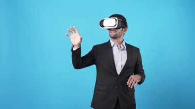 Finansal rapor hologramına bakarken finansal verileri yöneten akıllı bir proje yöneticisi. Yetenekli iş adamı elini hareket ettiriyor ve mali tablolara bakarken mavi arka planda duruyor. Aygıt.