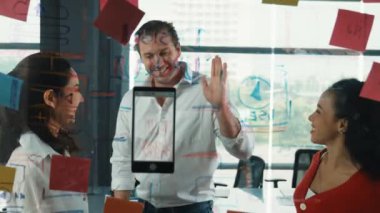 Mutlu iş adamları cam duvarda başarılı bir projeyi kutluyor. Profesyonel iş adamlarından oluşan bir grup el sıkışıyor, beşlik çakıyor, iş toplantısında başparmağını kaldırıyor. Yaratıcı iş. Yönlendirici.