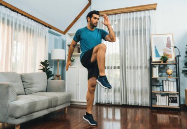 Atletik ve sporcu erkek vücut egzersizinde koşuyor. Formda fiziği ve sağlıklı spor yaşam tarzı için. Gaiety evde egzersiz eğitimi.