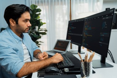 Akıllı IT geliştiricisi laptop ve iki pc ekranda kodlanan kağıtlar üzerine veri notları yazarak modern ofiste uygulama programı güncelleme sürüm sistemi yaratıyor. Tahmin et..