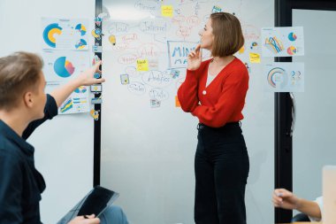 Erkek proje yöneticisinin yakın plan görüntüsü soru sormak için el kaldırırken, genç güzel lider zihin haritası ve renkli yapışkan notlar kullanarak iş projesini kendinden emin bir şekilde sunuyor. Tertemiz..