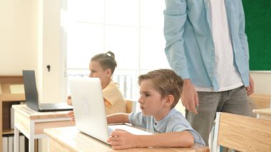 Bilgisayar üzerinde çalışan beyaz çocuğun yan görüntüsü. Mühendislik ödevi sırasında. Çekici çocuklar bilgisayar yazılımı kullanarak yapay zeka ya da programlama sistemini öğreniyor ya da öğreniyor. Pedagoji.