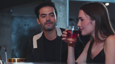 Barmen, dumanlı klasik viskiyi kokteyl ile karıştırıyor. Bir bayana içki tadıyor ve kulüpteki grup misafirlerine içecek tezgahında lezzetli bir içki ikram ediyor. Vinosity.