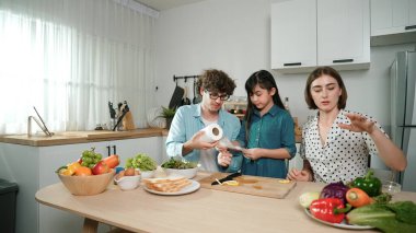Mutlu baba yemek pişirirken müziğe geçiyor ve modern mutfakta öğle yemeği hazırlıyor. Aktif baba, sebze ve mutfak gereçleri ile çevrili sağlıklı yemek ya da salata yaparken şarkıyla dans ediyor. Pedagoji.