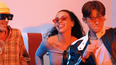 Liderli ya da neonlu ışıkla dans eden Asyalı adamla İspanyol kadının yakın çekimi. Profesyonel sokak dansçısı serbest stile ve canlı müziğe taşınırken gözlük ve bez takıyor. Mutluluk.