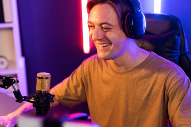 Oyun kanalı, online oyun oynayan akıllı flamalı oyun sunucusu, kulaklık takan, neon ışıklandırma odasındaki takım oyuncusuyla akıllı telefondan canlı yayında konuşan izleyiciler. Bireysel.