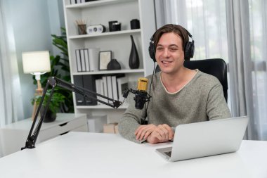 Sunucu kanalı, gülümseyen akıllı yayıncı kaydı, senaryosu ve akıllı telefonuyla sosyal medyada sohbet programı, kulaklık takarak modern ev stüdyosundaki video flamalarını kaydediyor. Bireysel.