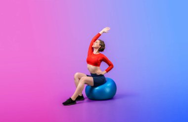 Vücut uzunluğunun tamamı atletik ve sportif genç bir bayanın izole edilmiş arka planda duran bir duruşta topa egzersiz yapmasıyla geçiyor. Sağlıklı aktif ve vücut bakımı yaşam tarzı.