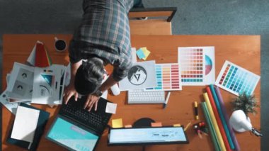 Kulaklıktan müzik dinlerken yetenekli iç dizayn grafiklerinin yukarıdan aşağı havadan görüntüsü. Proje yöneticisi kulaklıkla çalışırken ve rahat şarkılar dinlerken stüdyoda hareket ediyor. Sempozyum.