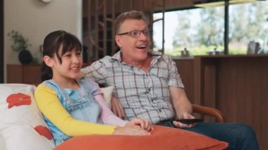 Büyükbaba ve torun birlikte TV 'de ilginç bir eğlence medyası izliyorlar. Eski üst düzey kullanım teknolojisi, genç nesil çapraz nesil ile iletişim kurarak aile bağlarını güçlendiriyor. Uyumsuzluk.