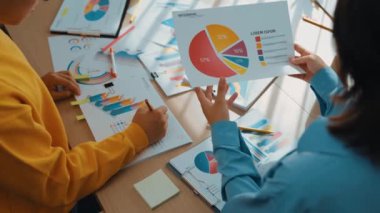Girişimci şirket çalışanları birlikte çalışır, finansal veri raporlama ve planlama stratejisi, panorama videosundaki yaratıcı iş başarısı için pazarlama içeren renkli BI gösterge panelini analiz eder. Sinerjik
