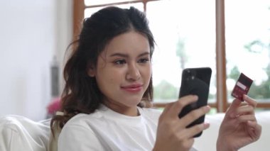 Kadın alışverişi ya da internet pazarında online ödeme modern yaşam tarzı için satılık eşyalar arıyor ve canlı siber güvenlik yazılımı tarafından korunan cüzdandan çevrimiçi ödeme için kredi kartı kullanıyor