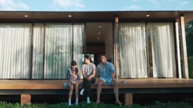 Şirin baba, anne ve kızı birlikte evin bahçesinde oturuyorlar. Ebeveynler, çevre farkındalığıyla ilgili genç nesli iletişim kurmak için açık hava aktivitelerini kullanırlar. Uyumsuzluk.