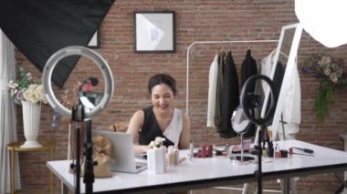 Kadın nüfuzlu kişi sosyal medya ya da blog için canlı yayın yapan video klip eleştirmeni derisini çekiyor. Canlı kozmetik stüdyosu ışıklandırması olan mutlu genç bir kız pazarlama için internet üzerinden yayın yapıyor..