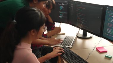 Yavaş çekim arkası yazılım geliştirici mühendisi bilgisayar programlama için birlikte çalışarak hata ayıklama kodunu çözüyor, ofiste monitörde karmaşık algoritmaları çözüyor. Filizlenen