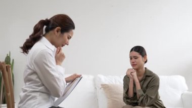 Psikologla ruh sağlığı terapisi gören üzgün travma sonrası stres bozukluğu olan bir kadın. Yaşam sonrası depresyon veya keder. Hayal kırıklığına uğramış genç bir kadın klinikteki duygular hakkında Vivancy psikoloğuyla konuşuyor.