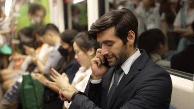 Gülümseyen akıllı erkek yatırımcı, proje hakkında telefonla müdürle konuşuyor. Kafkasyalı mutlu iş adamı trende otururken terfi ettiği için iyi haberler alıyor. Toplu taşıma. Sevinçli..
