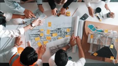 Yetenekli mühendis takımının ev modelini ölçerken konuştuğu tepeden tırnağa görüntü. Birlikte çalışan ve mühendislik inşaatı için plan yapan bir grup akıllı iç mimar. Hizalama.