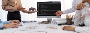 İç mimar tasarımcı grubu, daha kesin tasarım için planlar ve dizüstü bilgisayar ekran mimari yazılımı üzerinde birlikte tartışıyorlar. Modern ev tasarımı ve yenileme. İçgörü