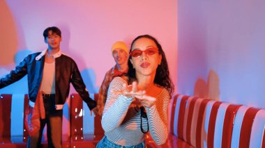 Çok kültürlü bir arkadaş birlikte dans ediyor ve hiphop müziği eşliğinde restoranda ya da kafede pembe neon ışıklı duruyor. Profesyonel sokak dansçıları grubu enerjik hareketler sergiliyor. Mutluluk.