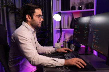 İki pc ekranda veri yazılım geliştirme analizi yapan akıllı bilişim geliştiricisi, neon ışıklı siber ofiste güncellenmiş uygulama programı güncellenmiş online web sayfası sistemi yaratıyor. Tahmin et..