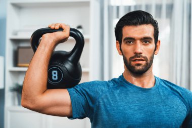 Atletik vücut ve aktif sporcu, sağlıklı vücut çalışma yaşam biçimi konsepti olarak eğlence evinde kas kazancı için kettlebell ağırlığını kaldırıyor..