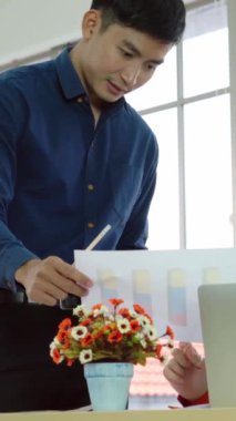 İki iş adamı toplantı odasında proje stratejisi hakkında konuşuyor. İş adamı, mali veri raporu hakkında sohbet ve tavsiyelerde bulunurken, modern işyerindeki iş arkadaşıyla proje planlamasını tartıştı.