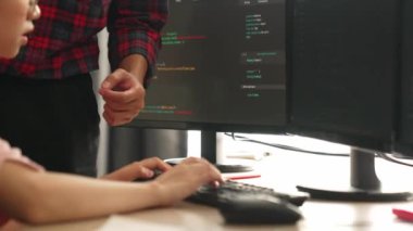 Yavaş çekimde geri uç veya yazılım geliştirici yöneticisi ekibini monitörde hata ayıklama ve karmaşık kod algoritmalarını çözmede yeni uygulama programı geliştirmede denetliyor. Filizlenen