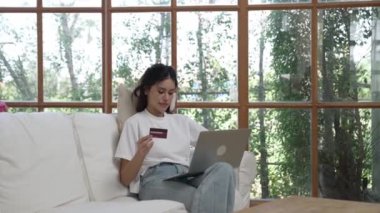 Kadın alışverişi ya da internet pazarında online ödeme modern yaşam tarzı için satılık eşyalar arıyor ve canlı siber güvenlik yazılımı tarafından korunan cüzdandan çevrimiçi ödeme için kredi kartı kullanıyor