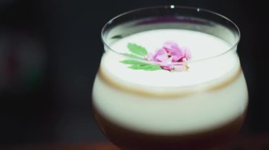 Tutkulu meyve suyu bardağında dönüşümlü, özel, ferahlatıcı, pembe çiçekle süslenmiş, lüks gece klübünde gece hayatı karışımı sergilenen bir içecek. Vinosity.