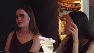 Güzel bir müşteriyle sohbet ederken limon dilimlenmiş votka kokteyli içerek sıcak ışık kulübündeki sosyal toplum ortamının keyfini çıkarmak. Vinosity.