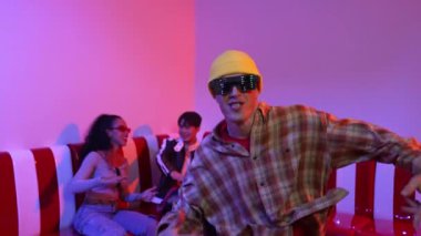 Kafkasyalı break dansçı çeşitli arkadaşlar birlikte dans ederken hareket eder. Çok kültürlü grup arkadaşını desteklemek ve cesaretlendirmek için el sallarken mutlu hipster hareketi. Mutluluk.