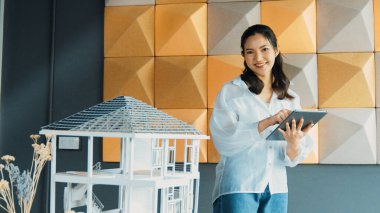 Tablet kontrol evi modelini kullanan güzel bir proje yöneticisi. Mimar mühendisinin portresi tabletteki veri analizini kullanarak bina inşaatını denetliyor. İş inşaat konsepti. Yönlendirici.