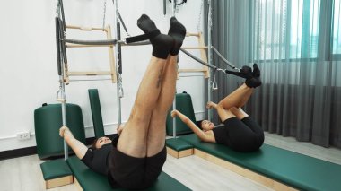 Bir grup müşteri, çekirdek dayanıklılığını ve bacak bağını geliştirmek için Cadillac reformatör makinesinde pilates egzersizleri yapıyor. Sağlıklı müşterilerin daha düşük poz verip kaldırma pozlarının üst görüntüsü. Sağlıklılık. Alışkanlık.
