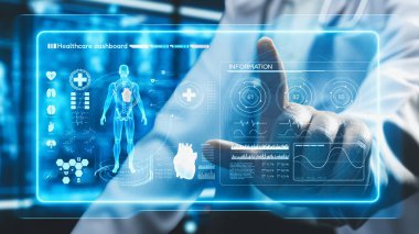 Yetenekli doktorların oturduğu ve insan anatomisi hologramına işaret ettiği yakın çekim. İnsan vücuduna HUD gösterge paneli kullanarak erişip tıbbi verilerle bağlantı kuran bir tıp çalışanı. İyileştirici.